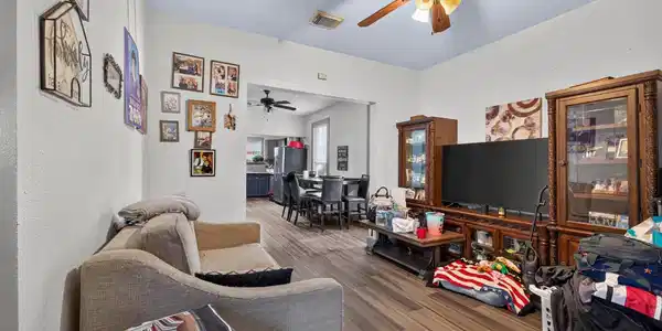 Image 4: Living room view showing a ceiling fan, TV media c