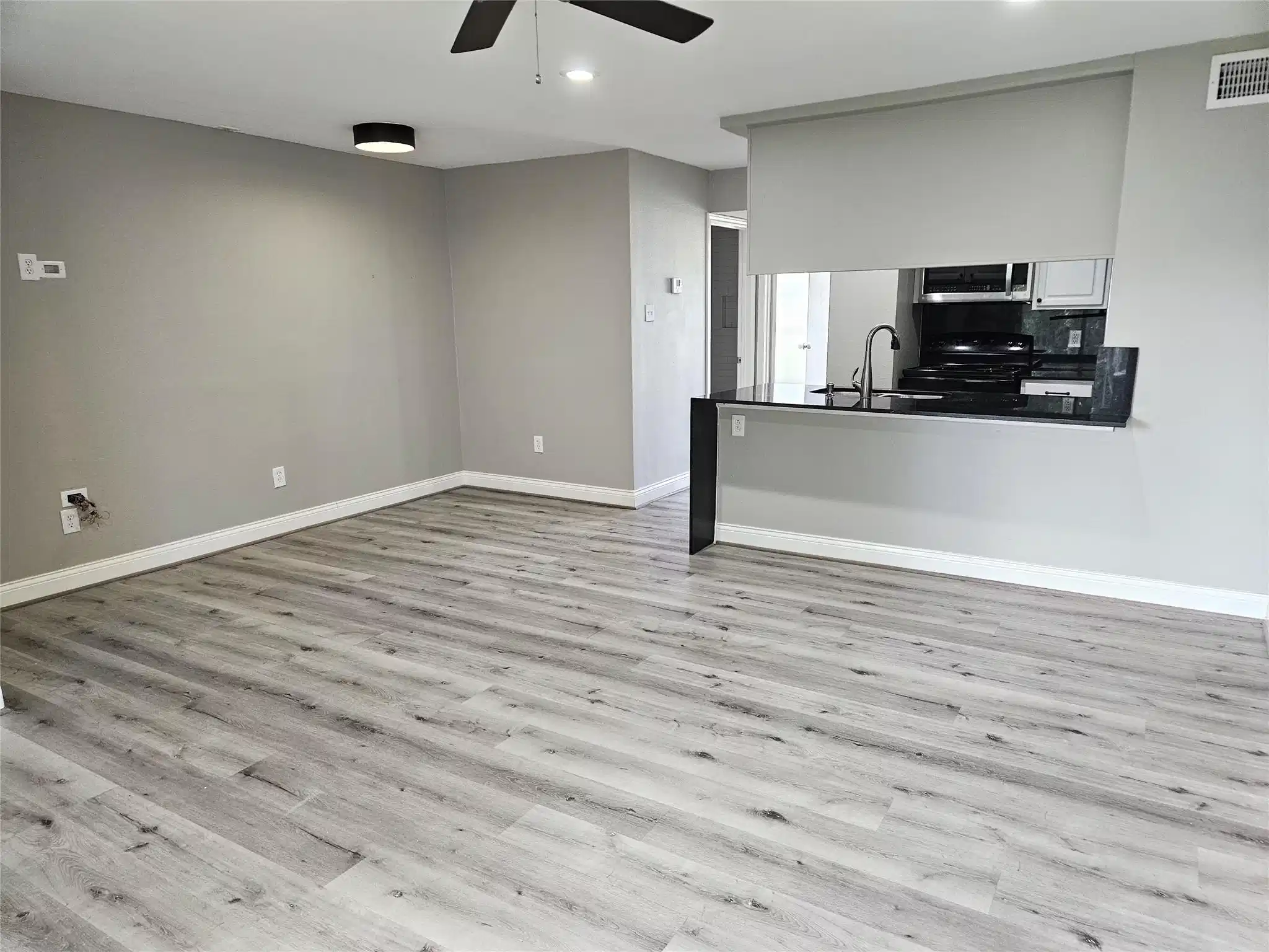 Image 1: The living room and dining area feature laminate f