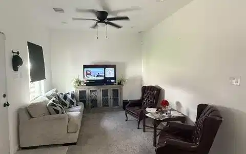Image 2: Cozy living room with neutral tones. The room has