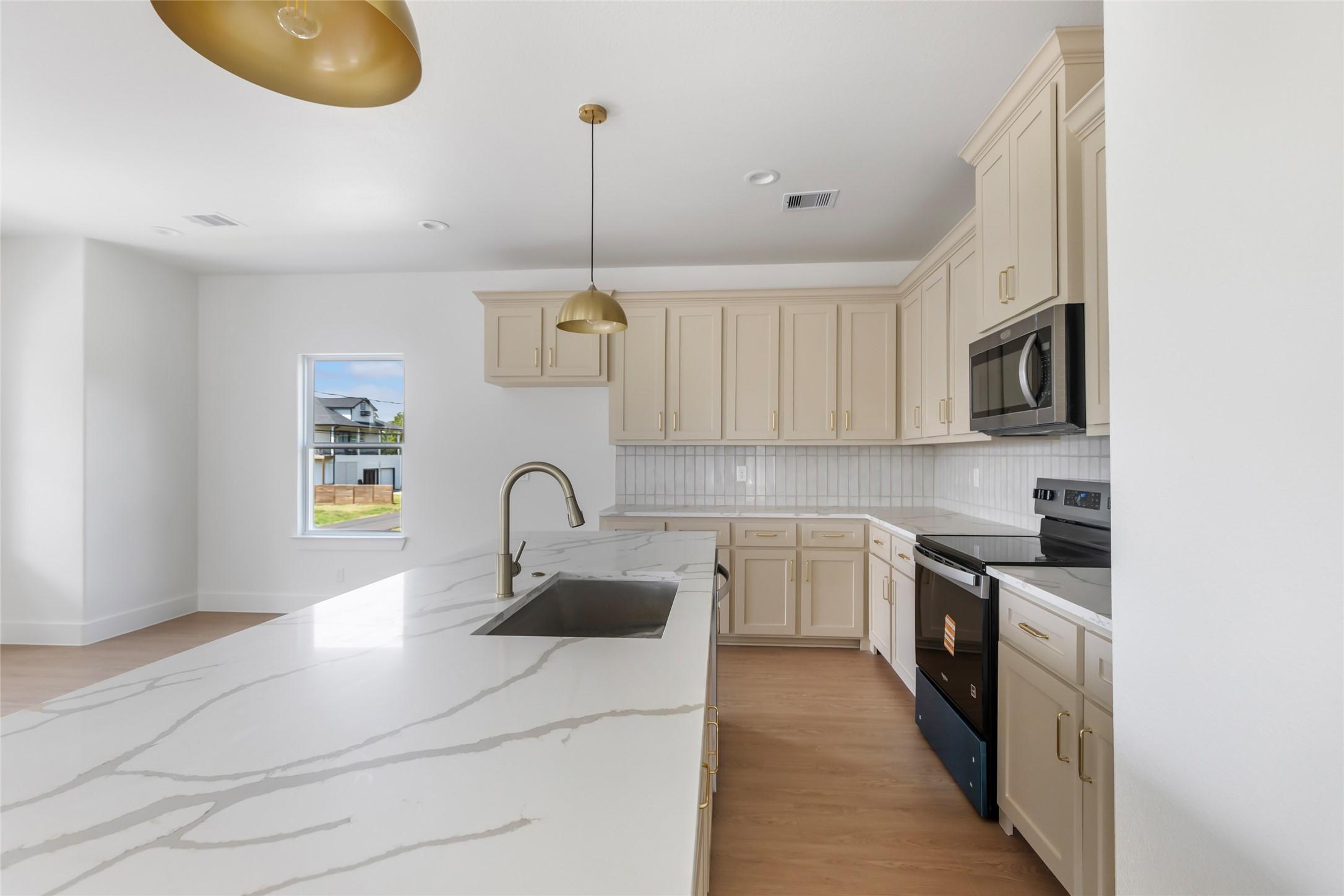 Image 4: Large island with elegant quartz countertops.