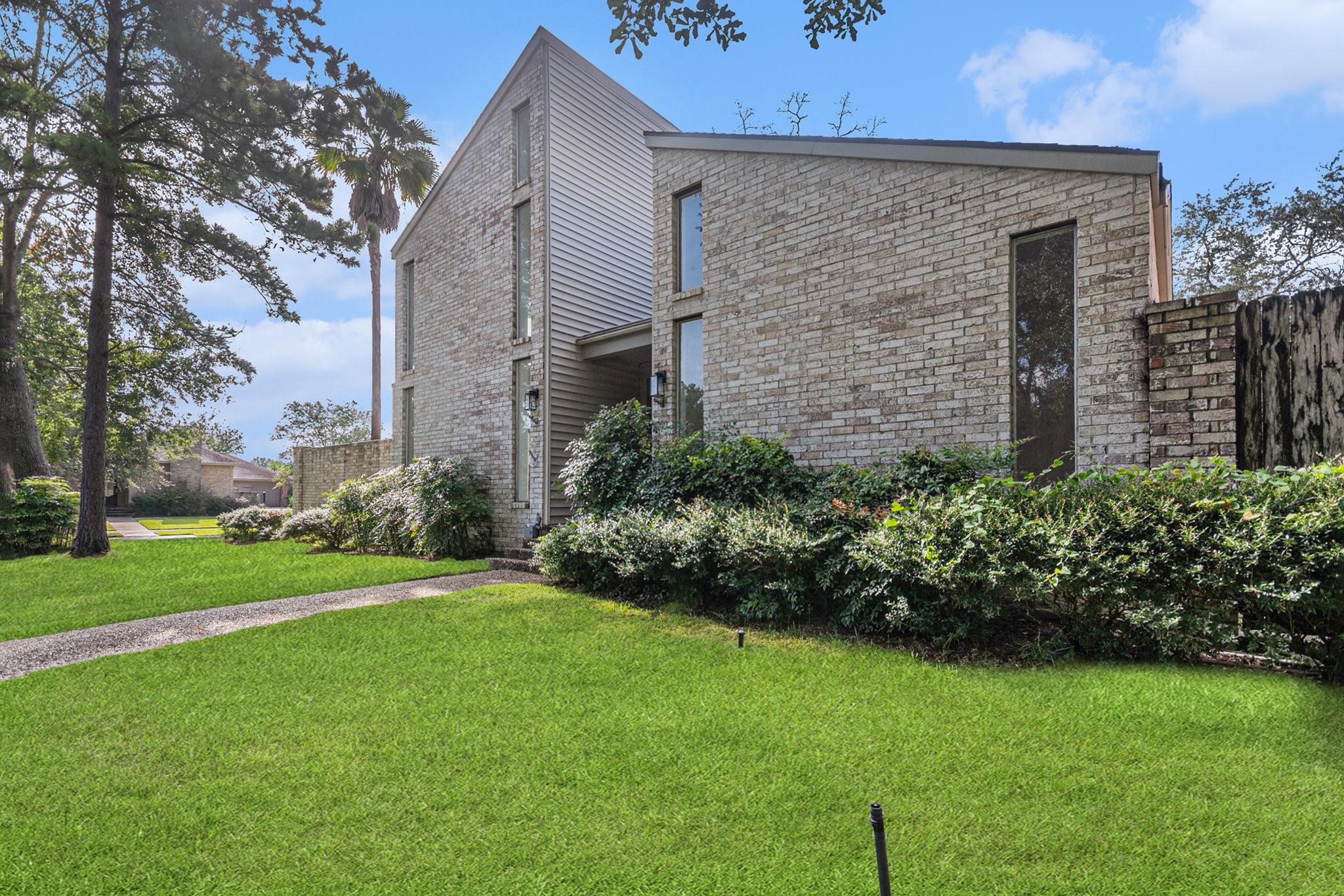 Image 3: Modern brick home with a sleek design, surrounded