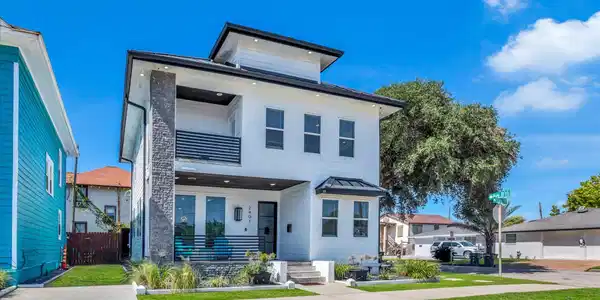 Image 3: Modern two-story home with a white exterior, contr