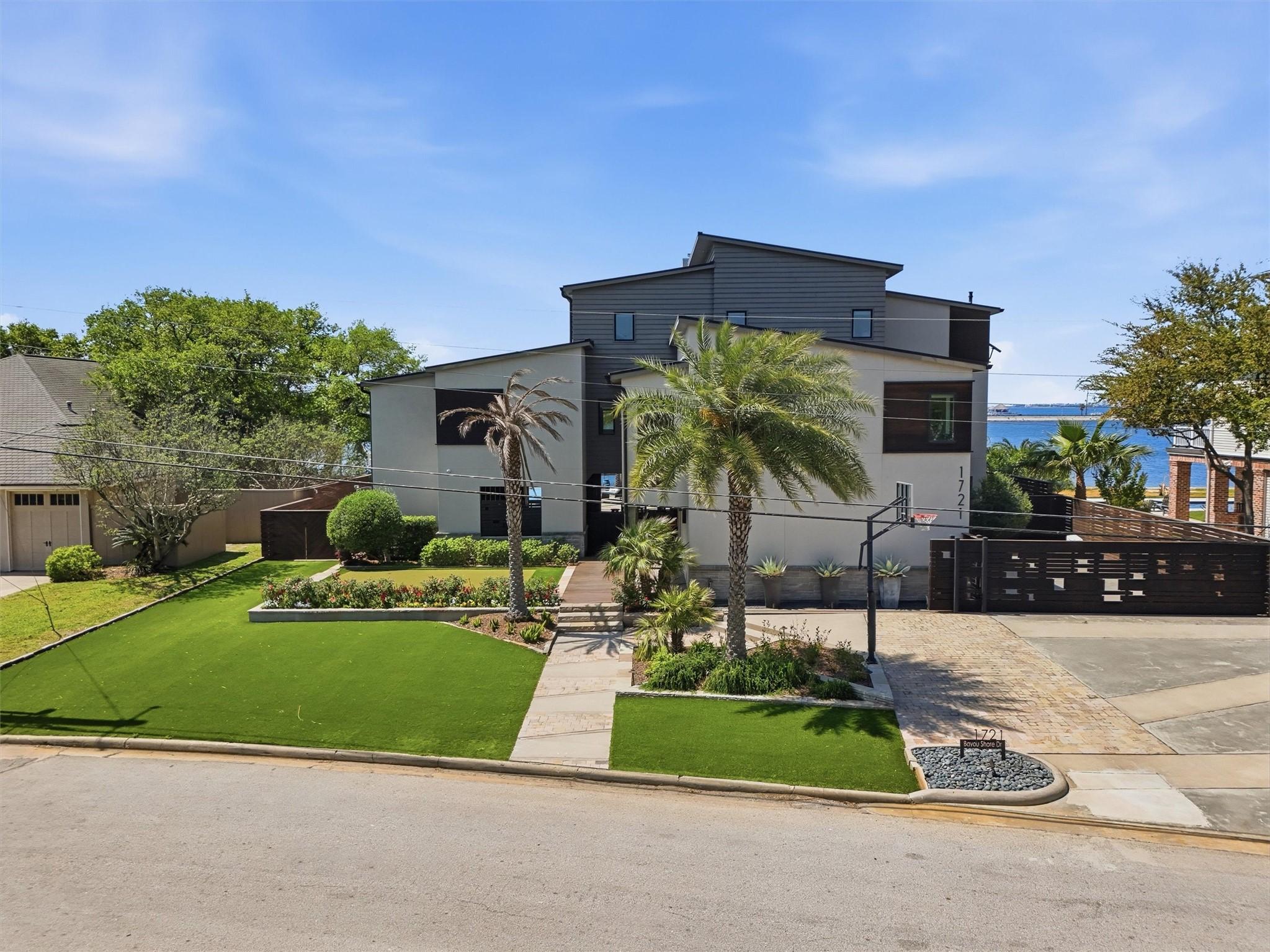 Image 2: Striking front yard featuring a putting green, bea