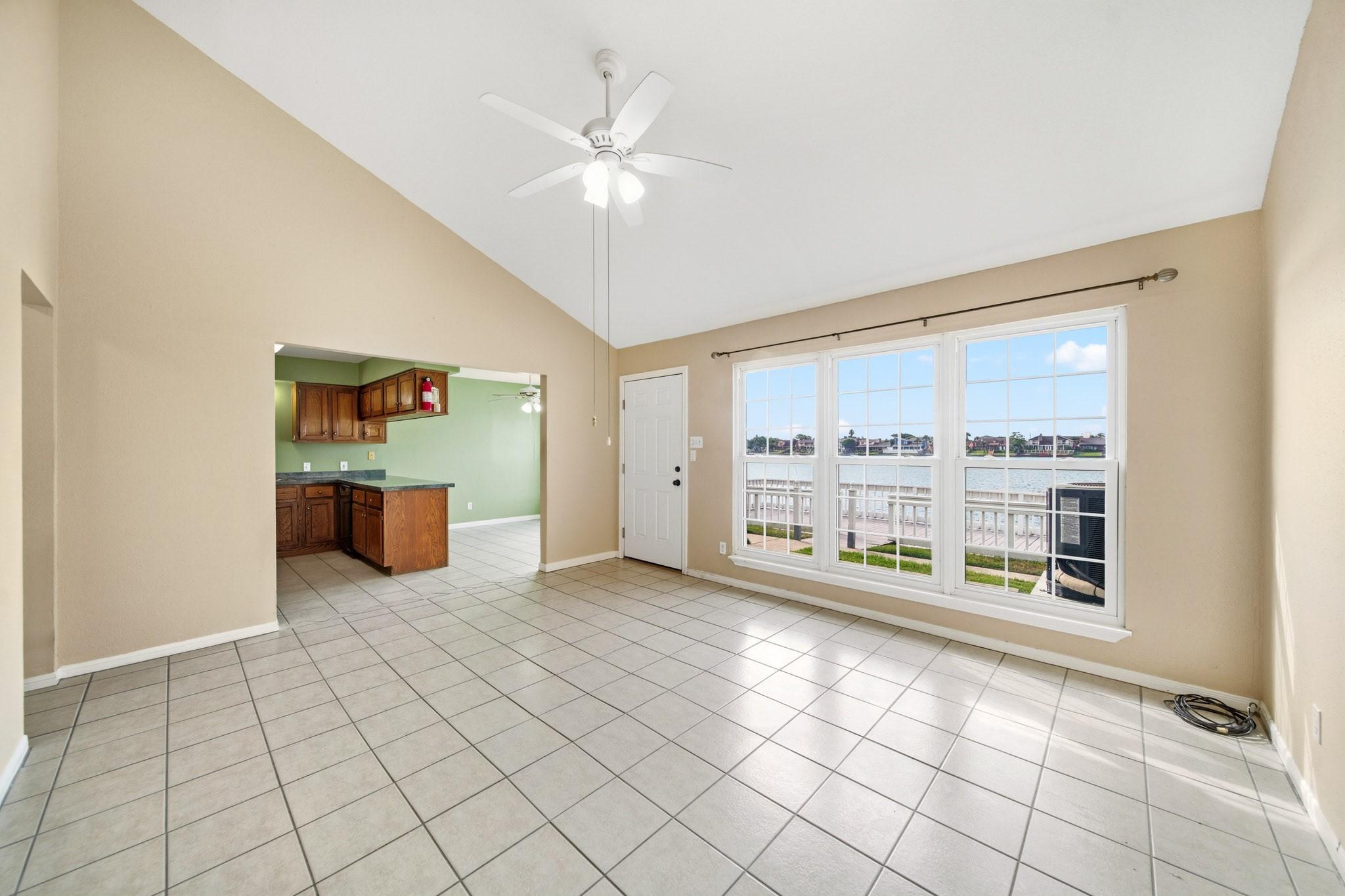 Image 3: The living area opens to the kitchen and dining ar
