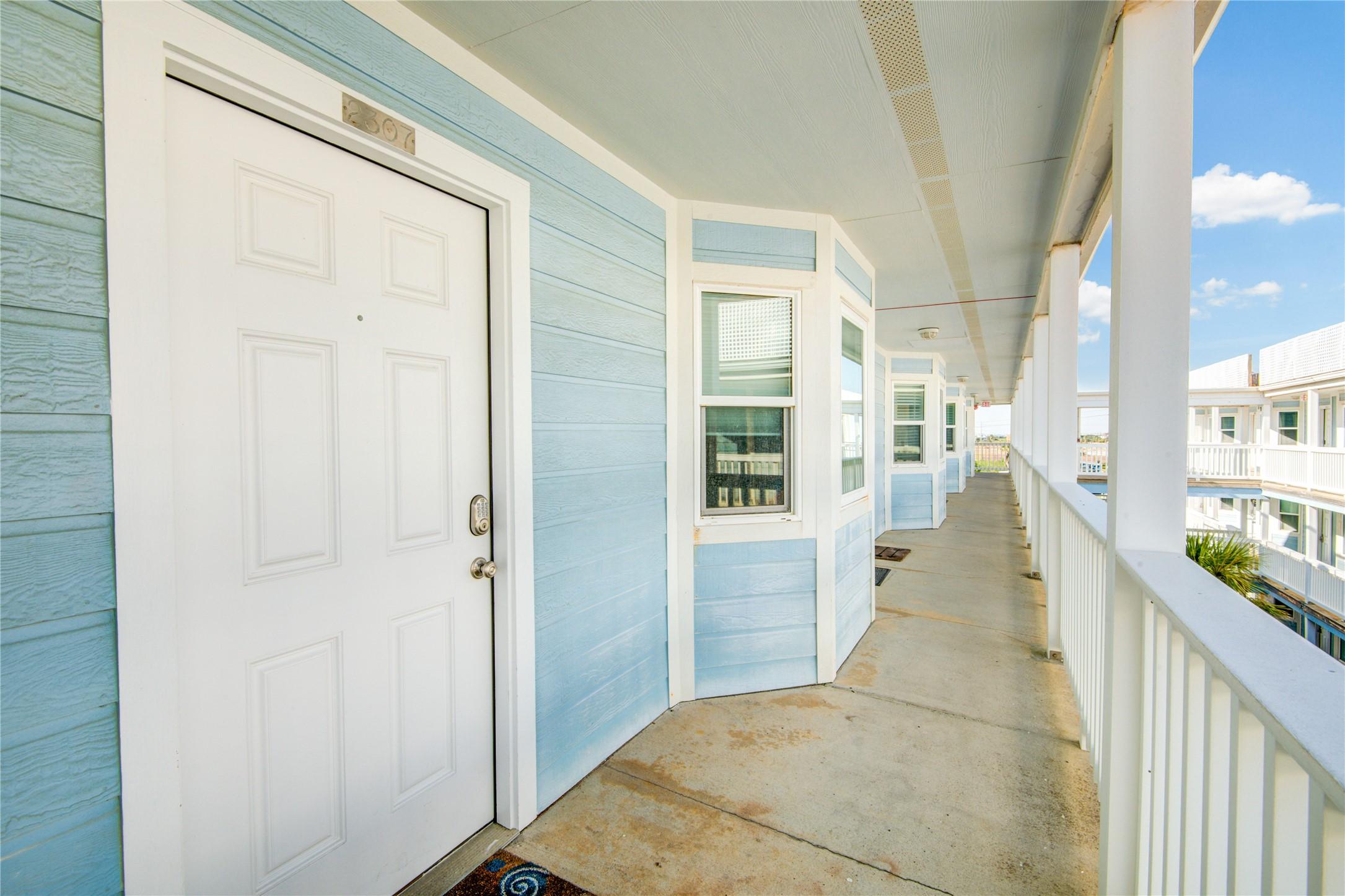 Image 2: This photo shows a light blue exterior hallway of