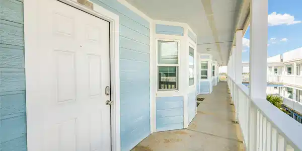 Image 2: This photo shows a light blue exterior hallway of