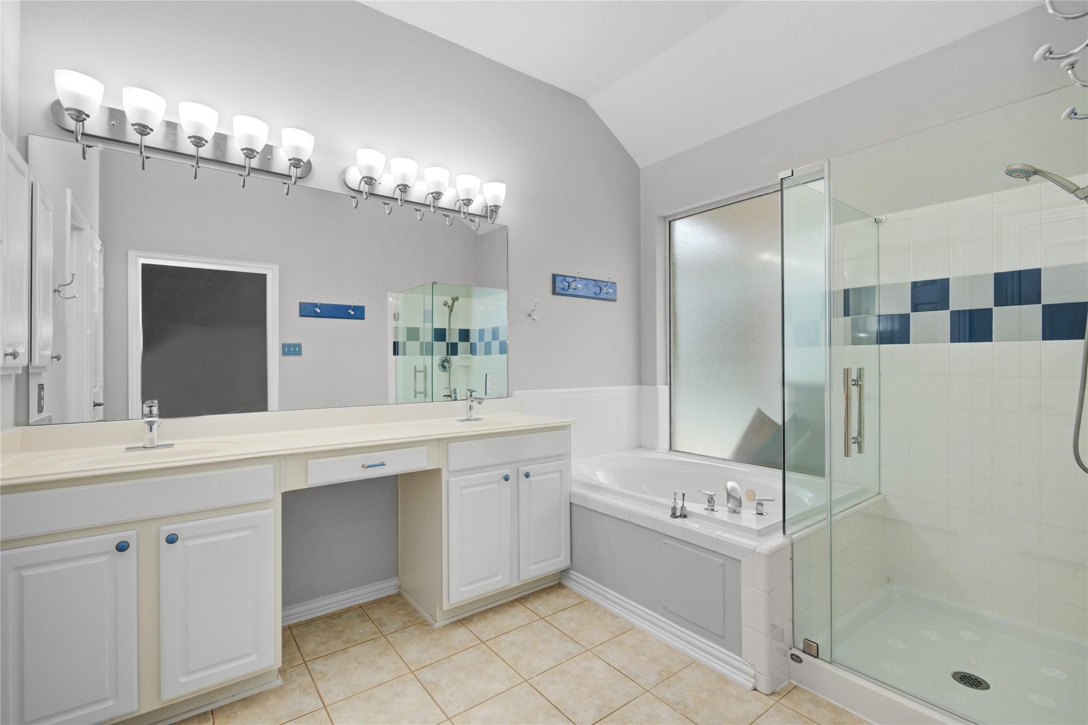 Image 4: Primary bath has standup shower and soaking tub.