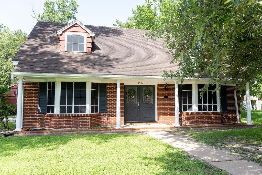 Image 2: Charming two-story brick home with a gabled roof a