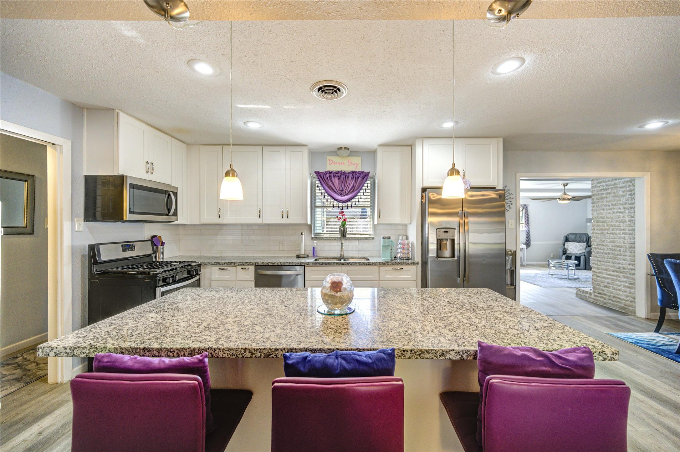 Image 2: This modern kitchen features granite countertops,