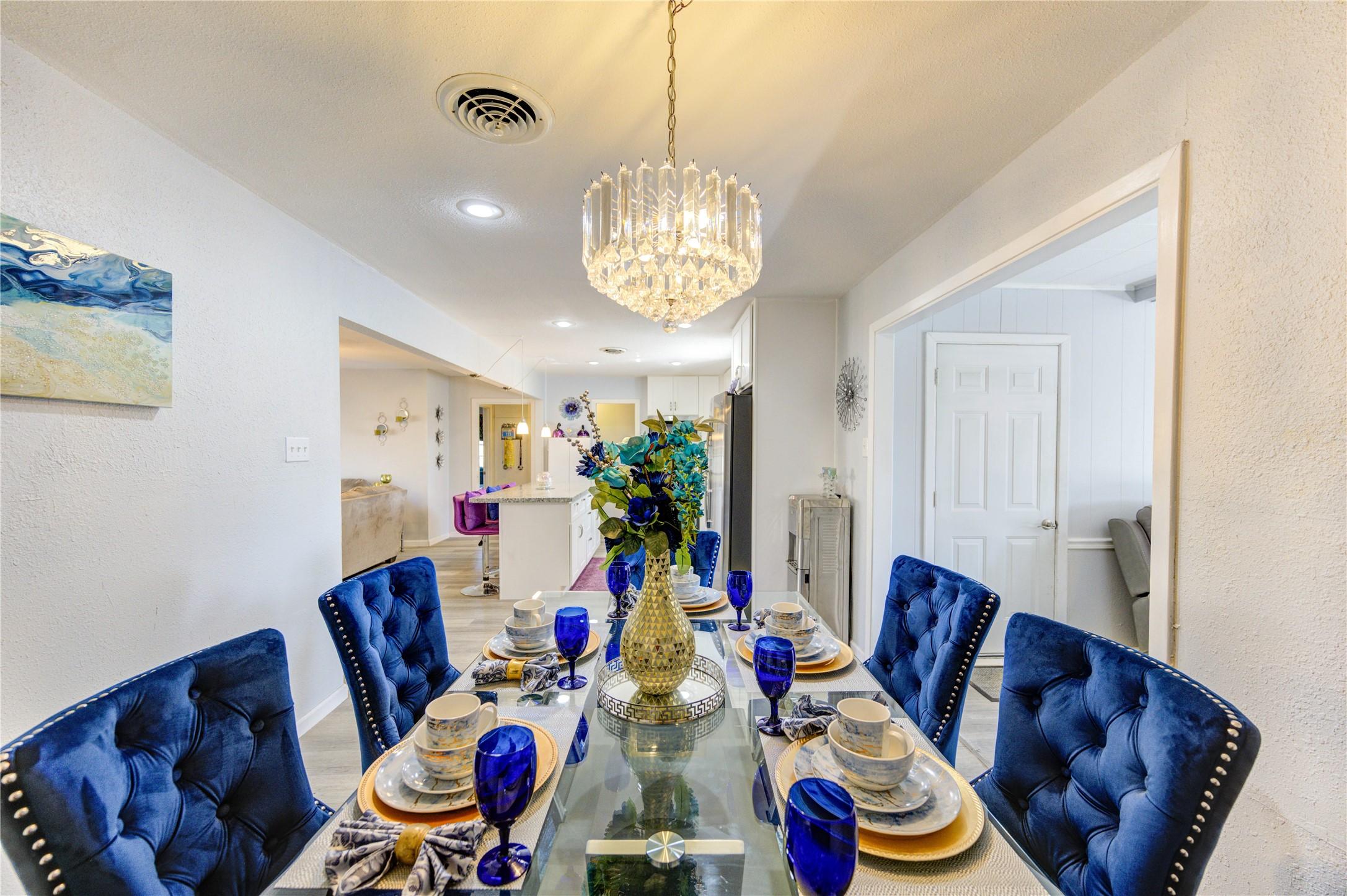 Image 3: The dining room features a beautiful chandelier an