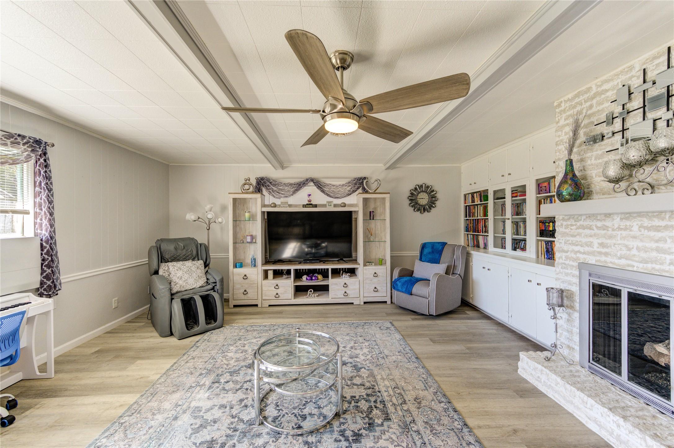Image 4: The den features a modern ceiling fan, built-in bo