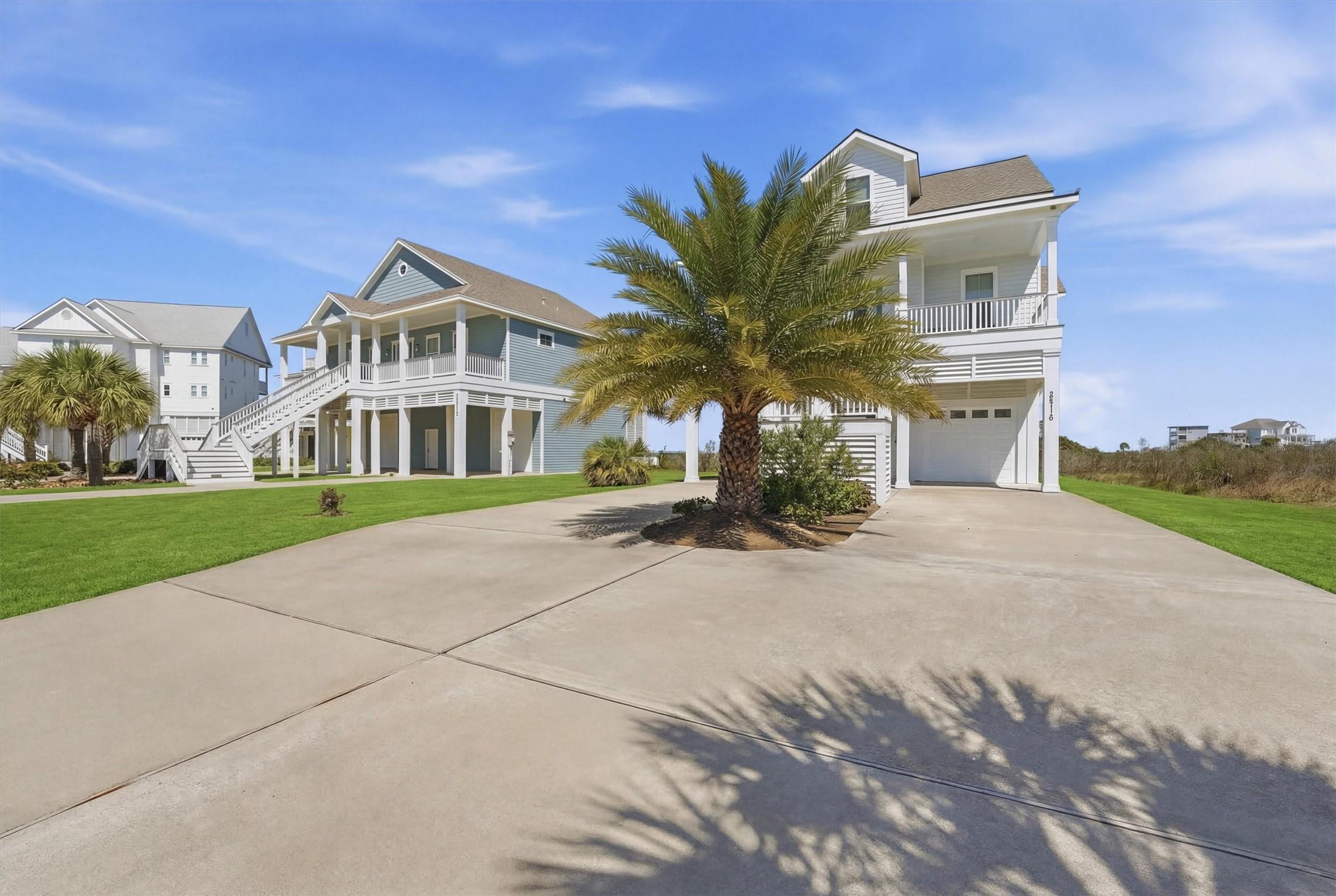 Image 2: A spacious driveway leads to this elevated coastal