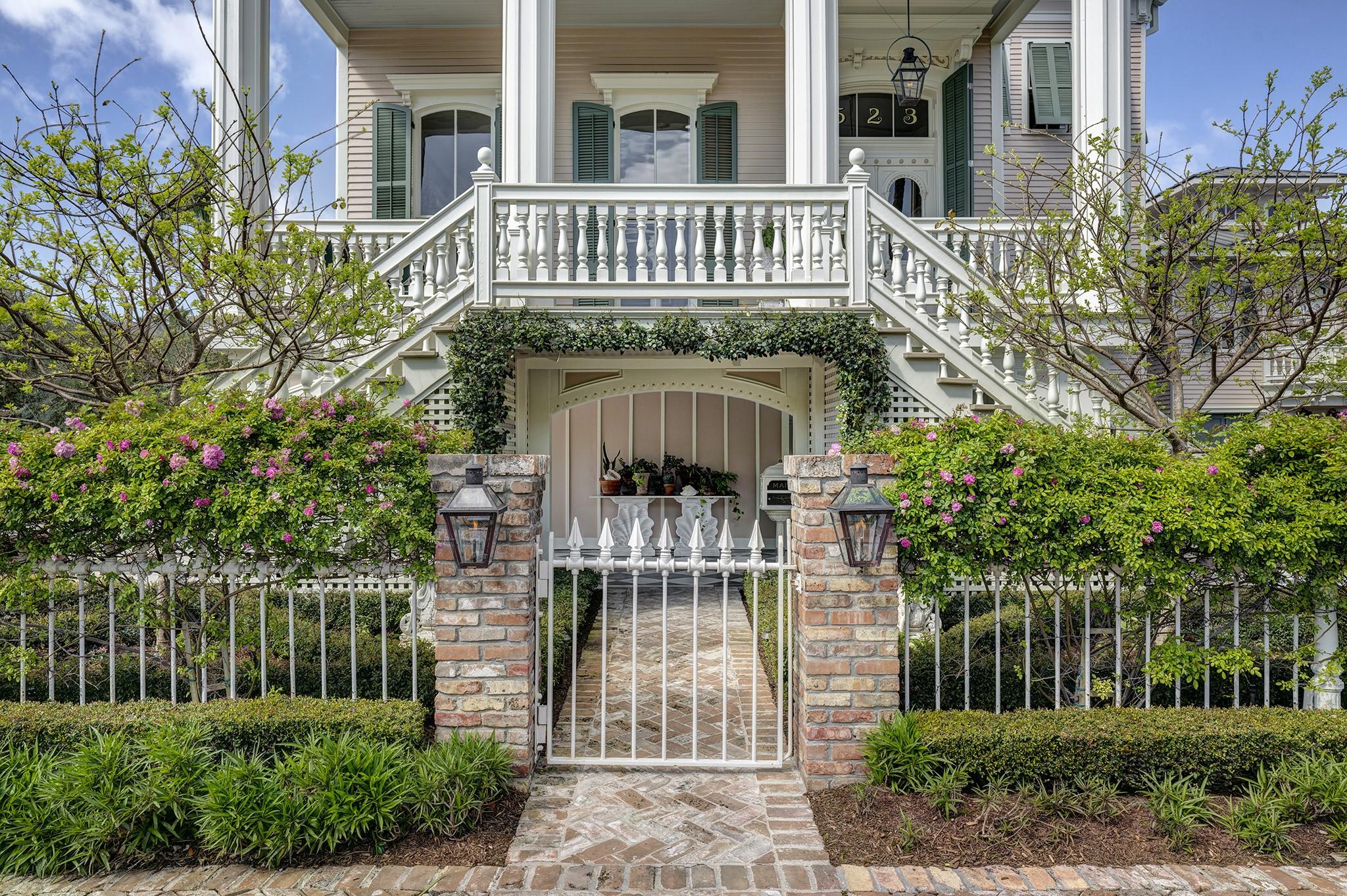 Image 3: Garden gate entry with brick piers, lanterns, and