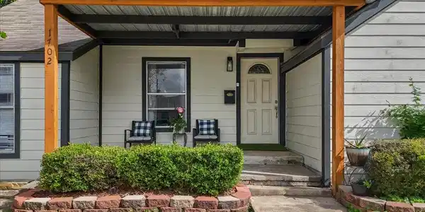 Image 3: Inviting front exterior with a covered porch, warm