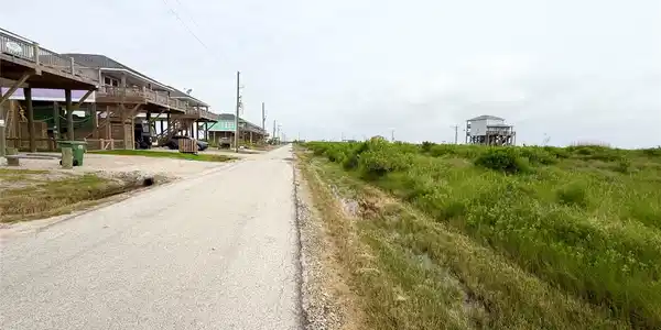 Image 4: Charming elevated homes line a quiet coastal road,
