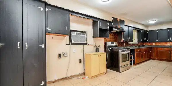 Image 2: The kitchen offers a functional layout with a stov