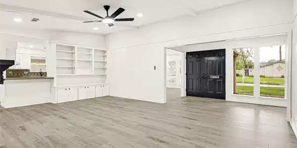 Image 3: This spacious living area features elegant wood fl