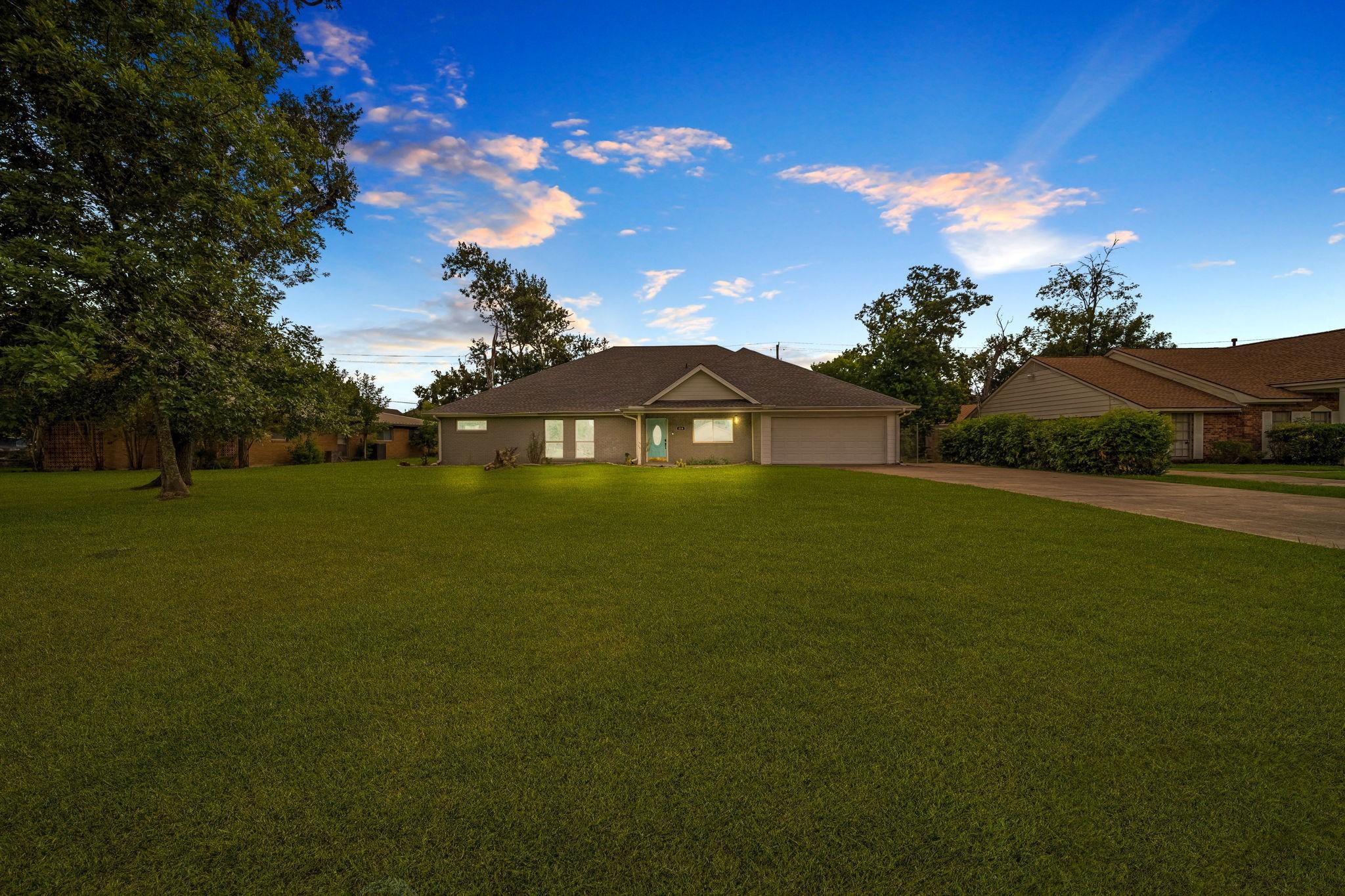 Image 2: Expansive front lawn welcomes you to this charming