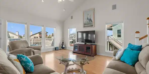 Image 4: The spacious living room features soaring ceilings