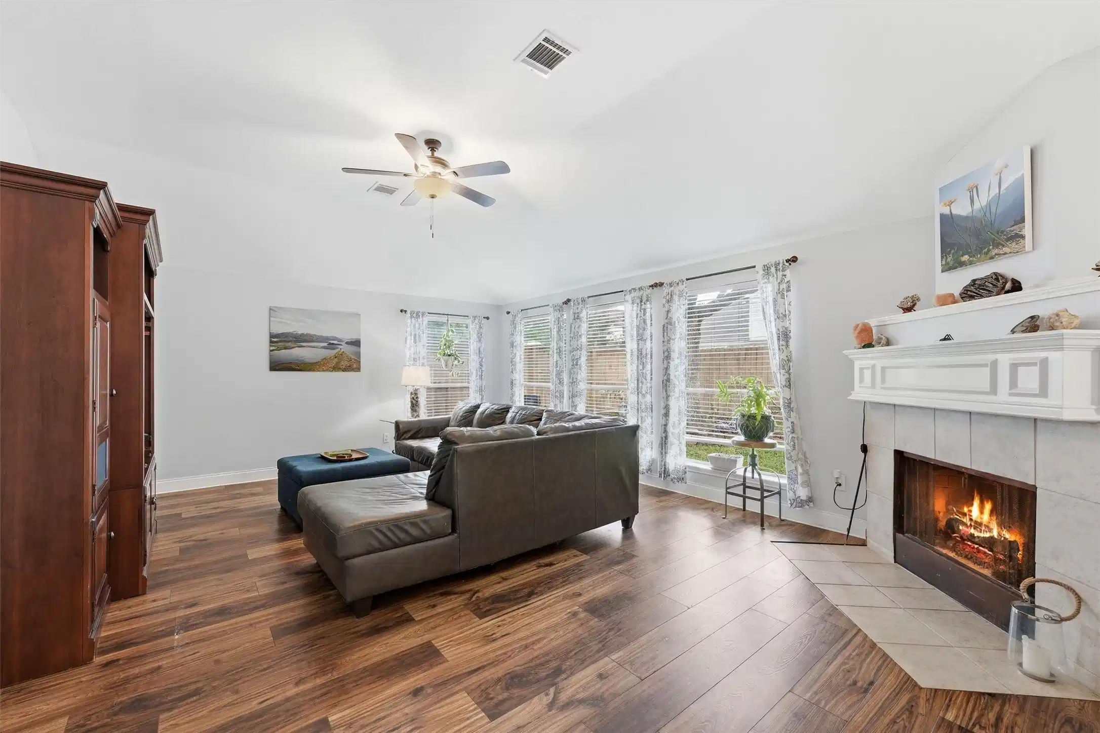 Image 1: Living room features a cozy fireplace, abundant na