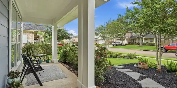 Image 3: Inviting front porch overlooking the landscaped fr
