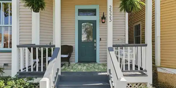 Image 2: Inviting front porch with classic columns and elev
