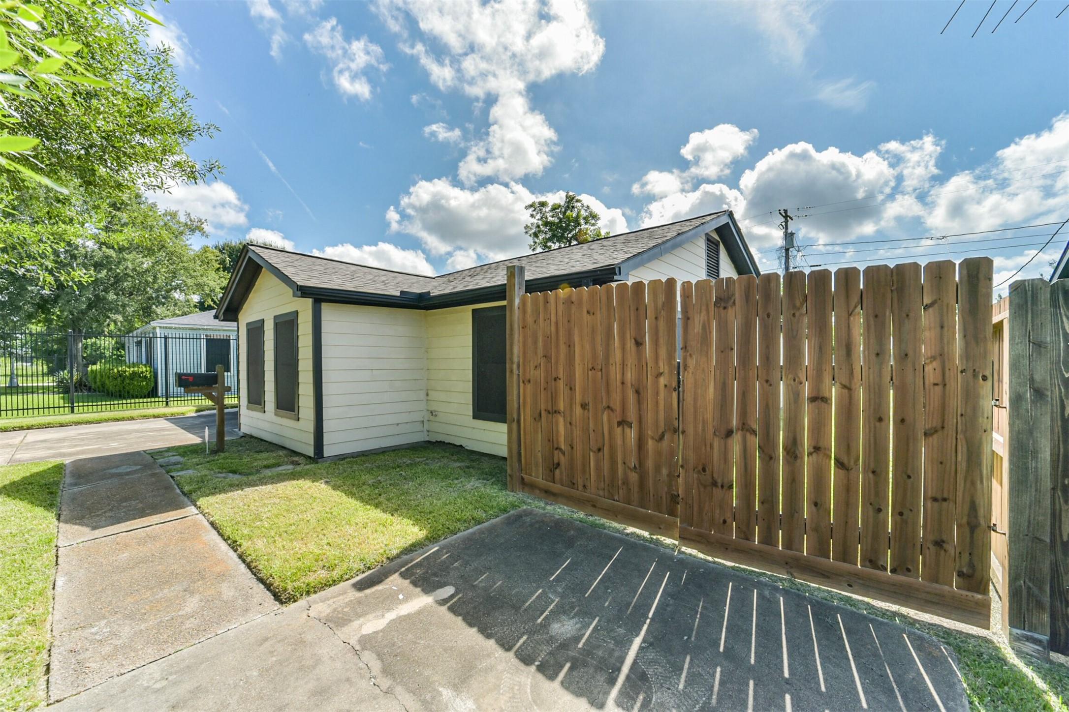 Image 4: Light exterior, nestled behind a wooden fence, off