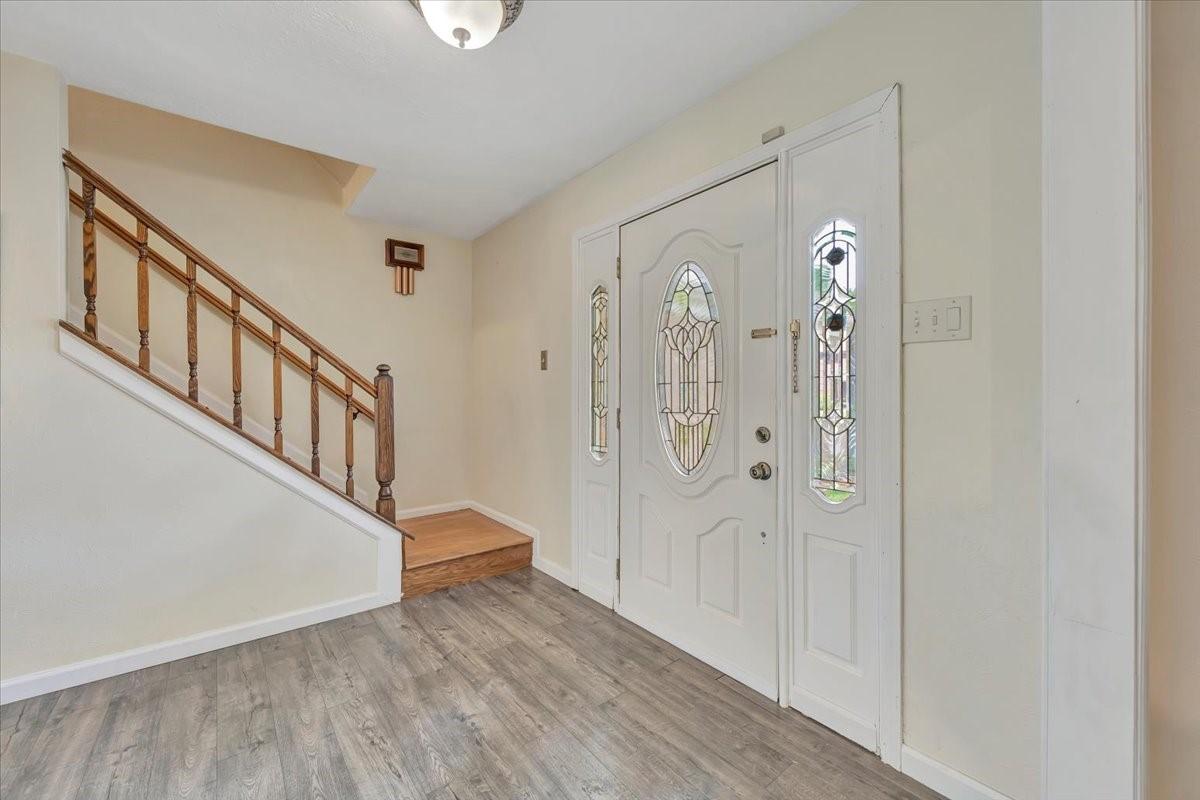Image 3: Another angle of the foyer with stairs in view.