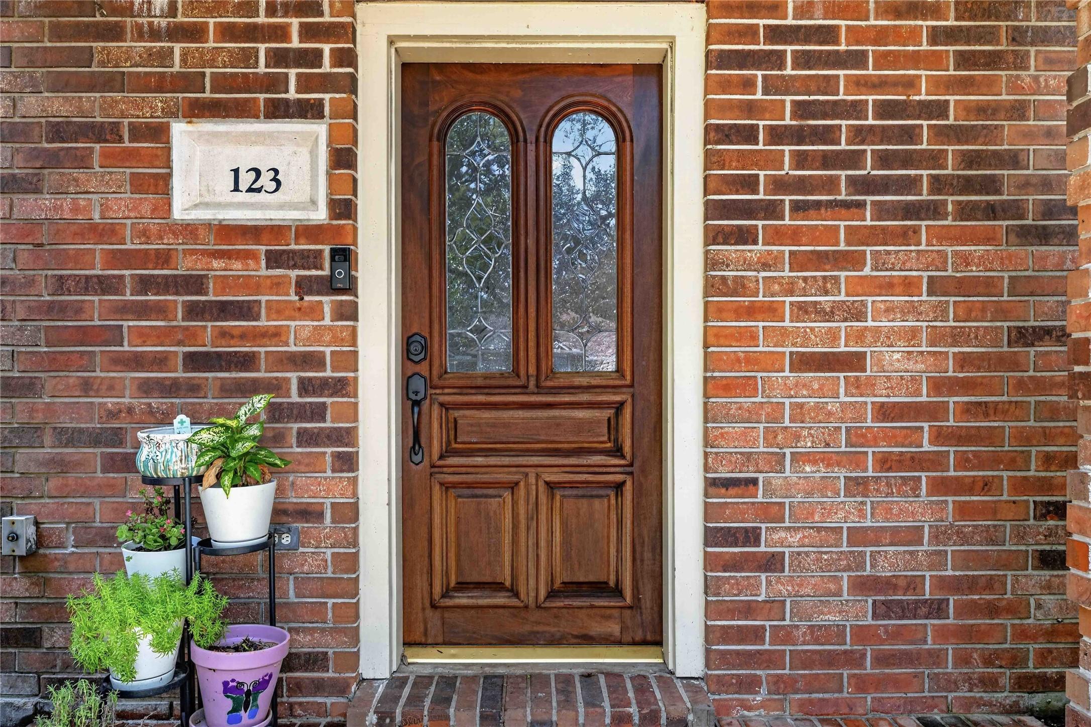 Image 3: Charming brick entryway with a rich wooden door fe