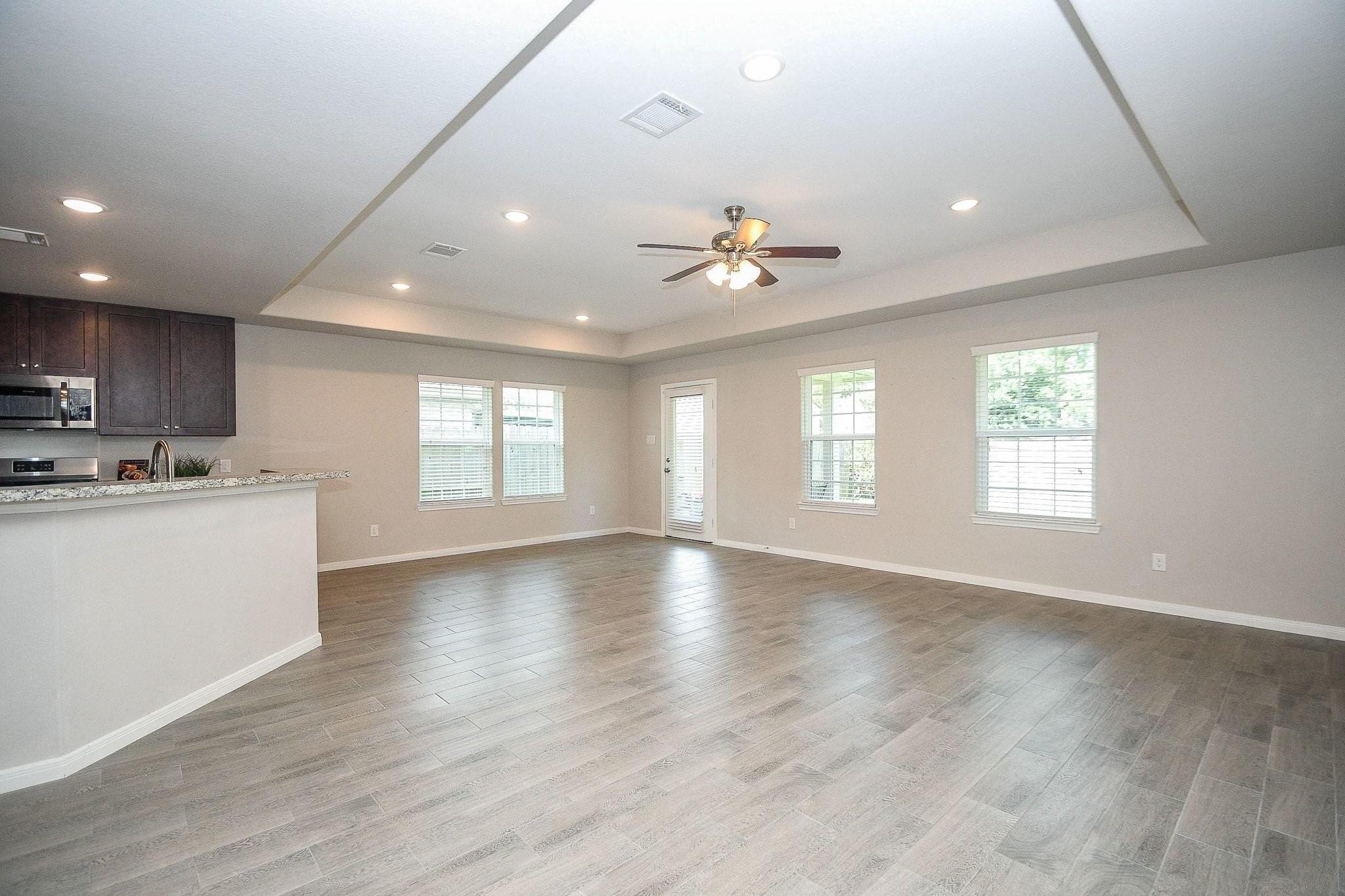 Image 4: Large living/dining area with wood look tile throu