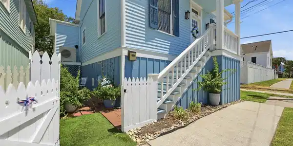 Image 3: Welcoming front entry framed by a white picket gat