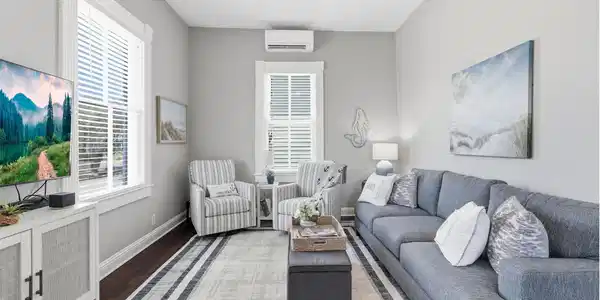 Image 4: Light-filled living room featuring tall windows, o