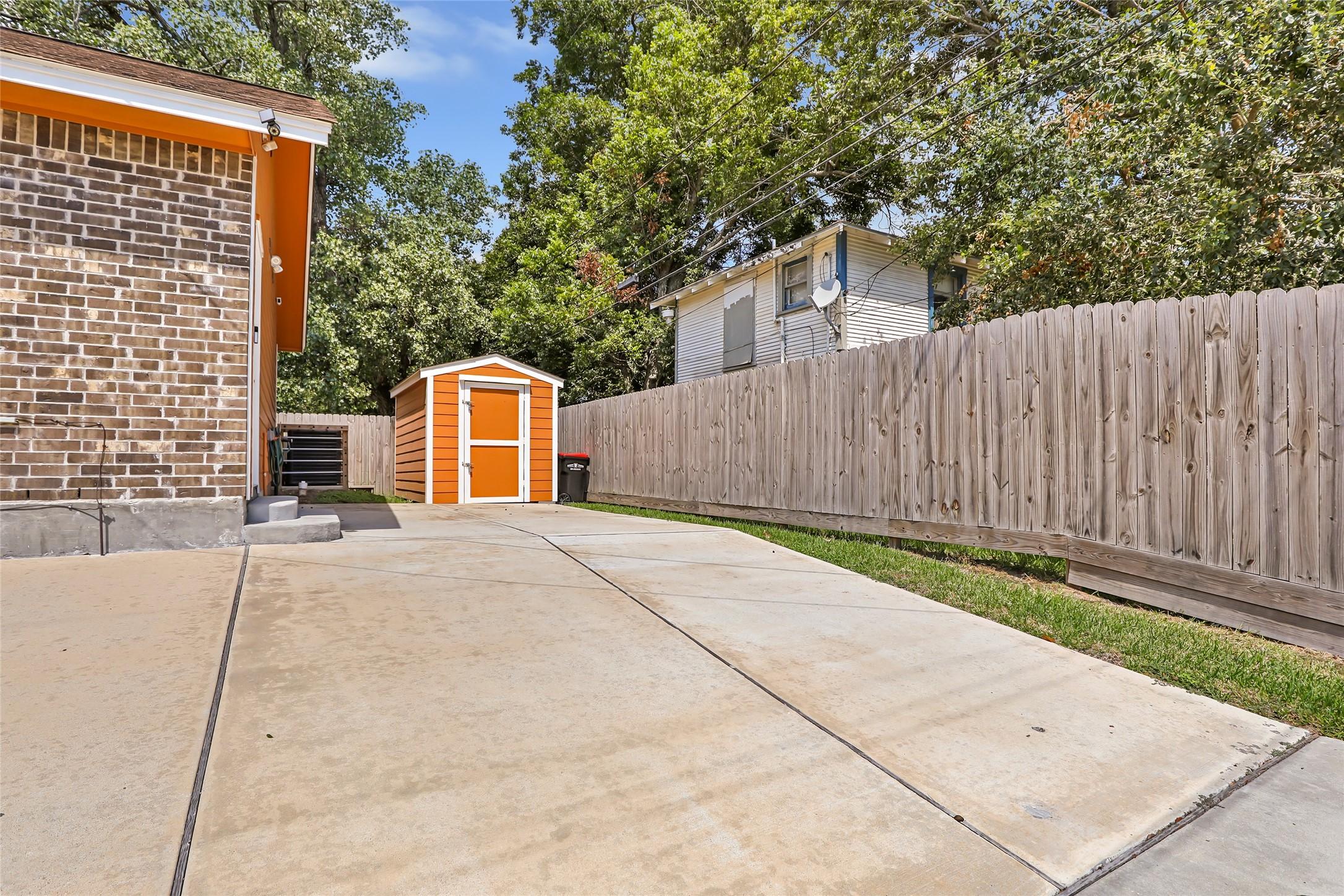 Image 4: parking area behind the home with a side street ae