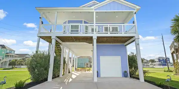Image 2: This elevated, modern coastal home features a spac