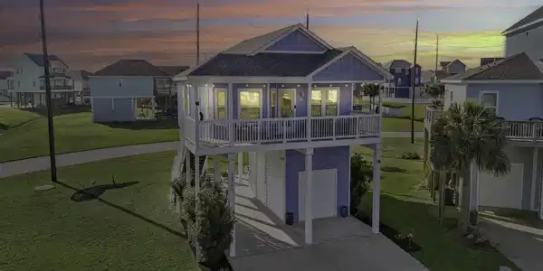 Image 3: Elevated modern coastal home with a spacious balco