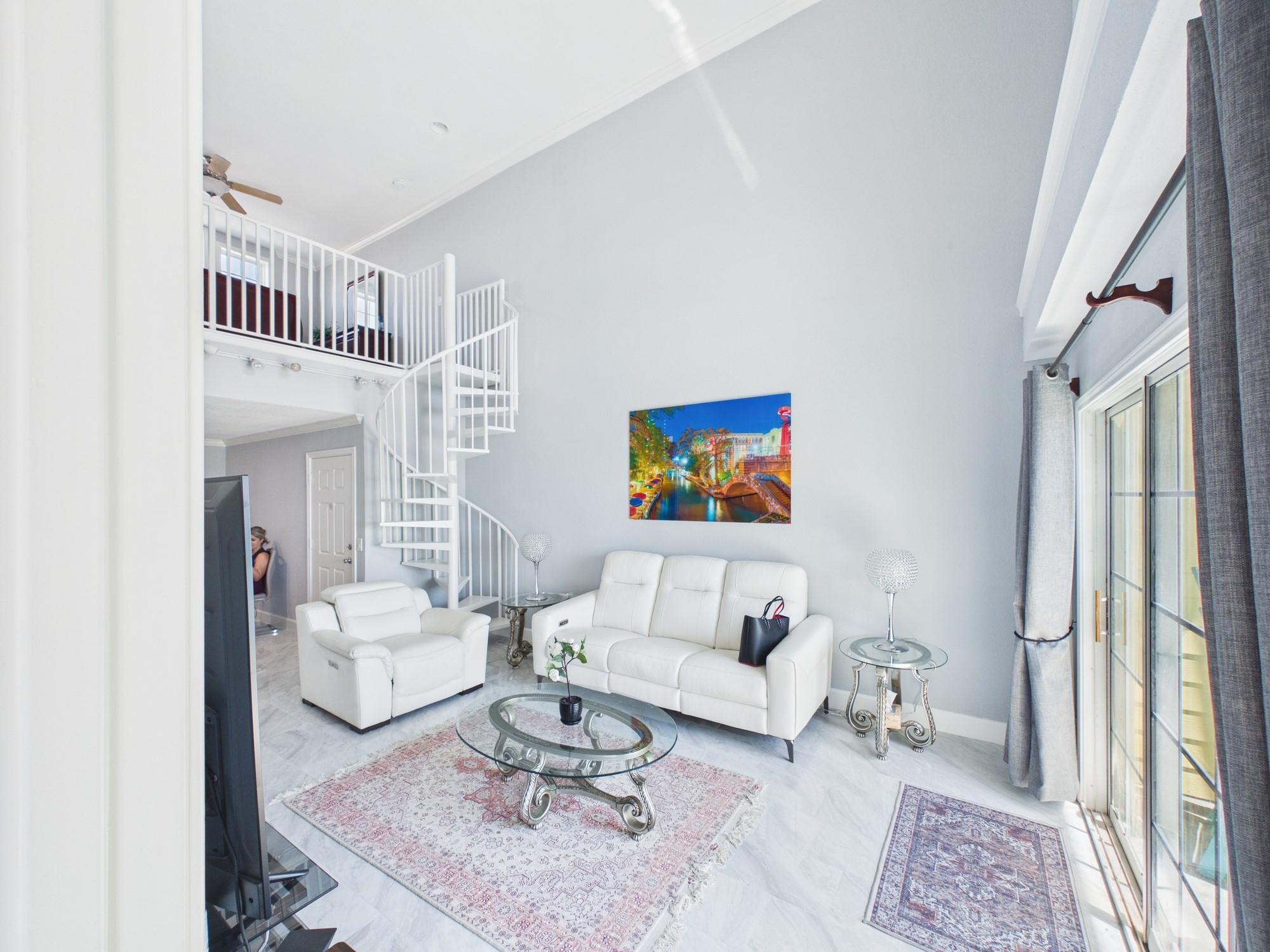 Image 3: High Ceilings with Spiral Staircase Leading to a L