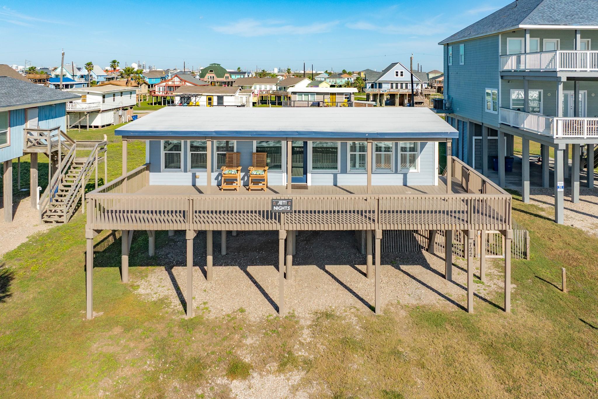 Image 1: Front Exterior &ndash; Elevated coastal home featuring a