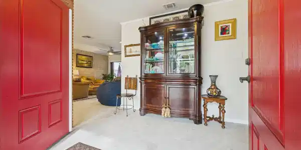Image 2: Inviting entryway with vibrant red doors opens to