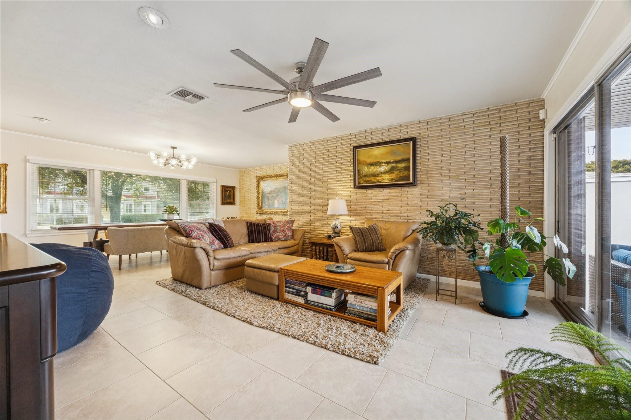 Image 4: This inviting living room is brightened by large w