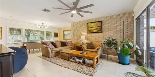 Image 4: This inviting living room is brightened by large w