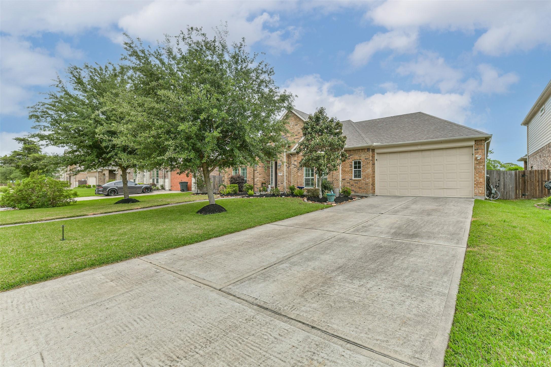 Image 2: Double-wide driveway leading to a spacious 4-car t