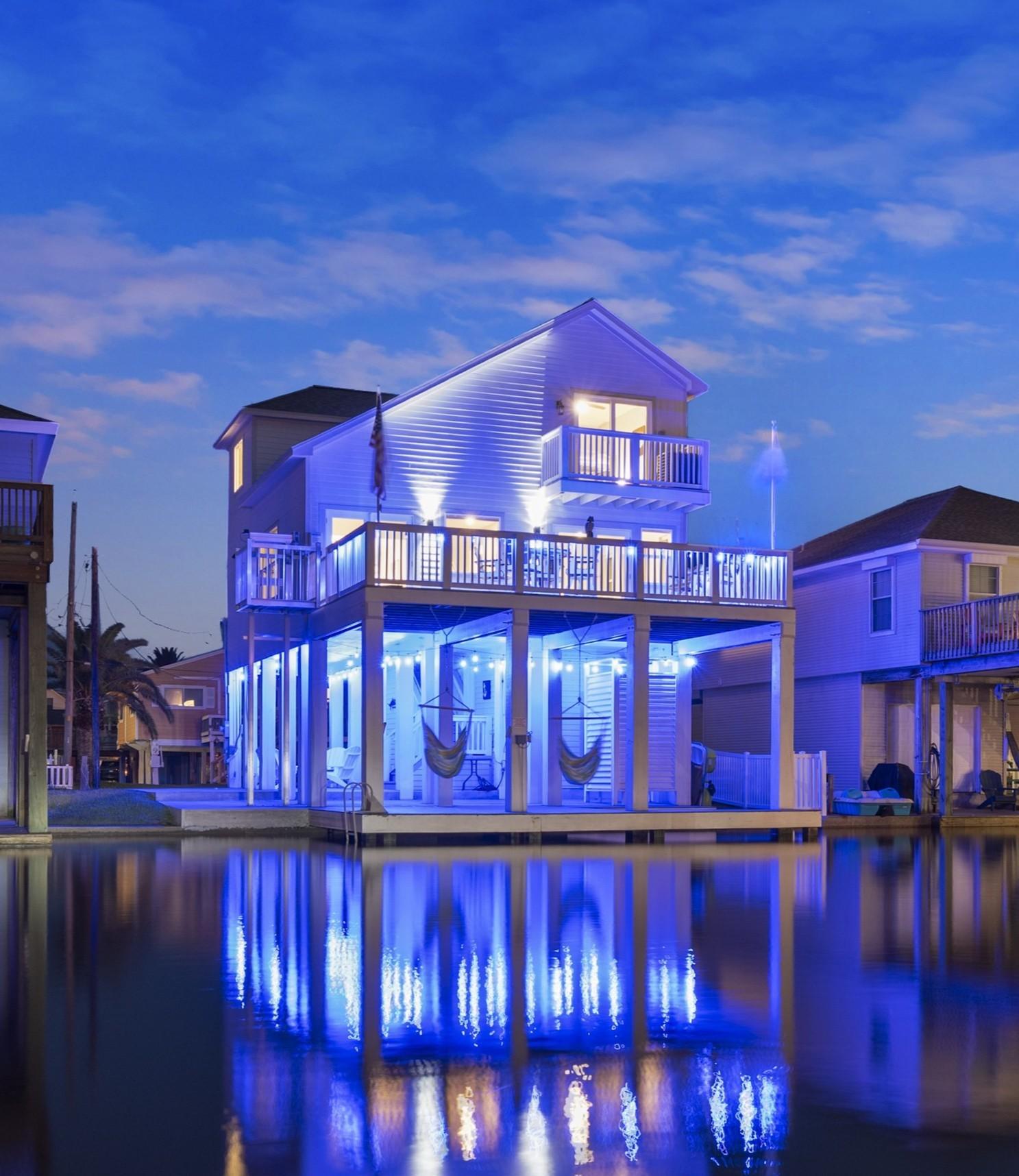 Image 1: View of the property at night w blue LED lighting