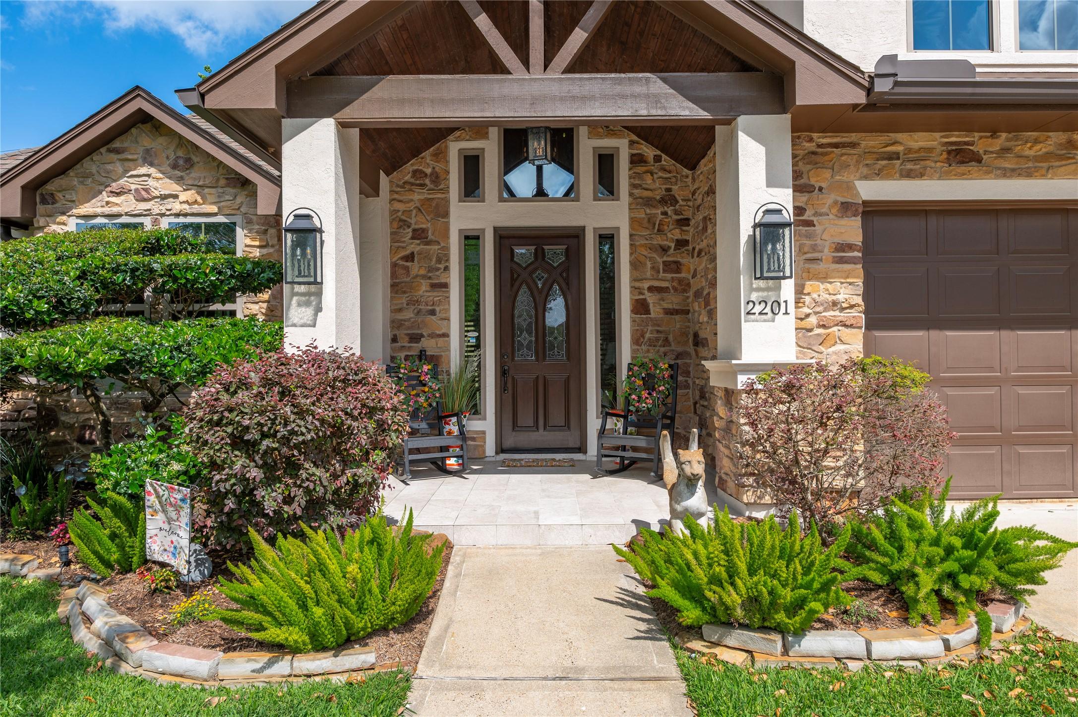 Image 2: Charming stone-front home with a welcoming porch,