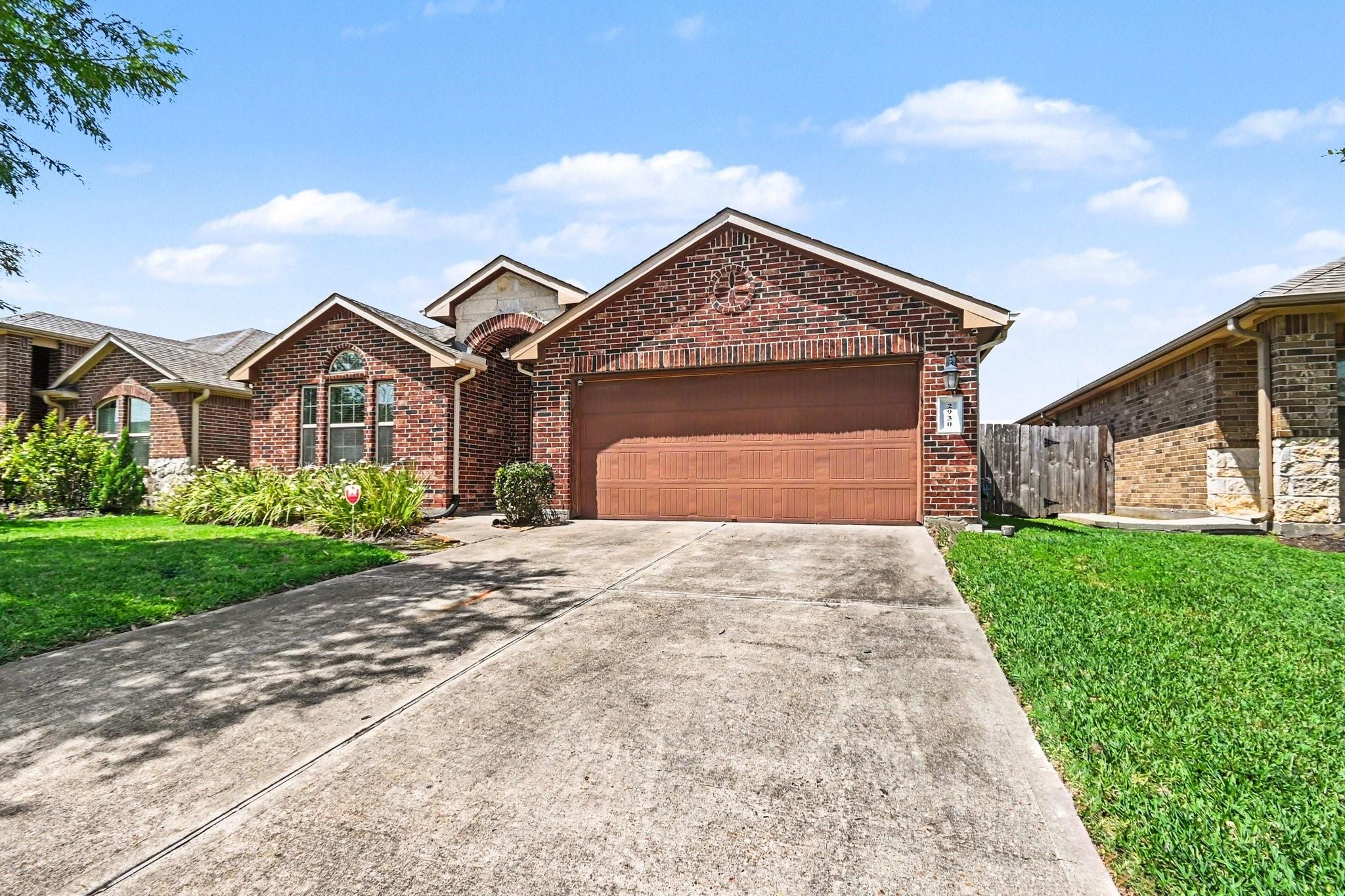 Image 3: This brick home features a two-car garage, manicur