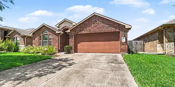 Image 3: This brick home features a two-car garage, manicur