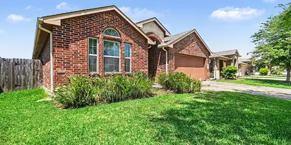 Image 4: This home with a welcoming arched window and tidy