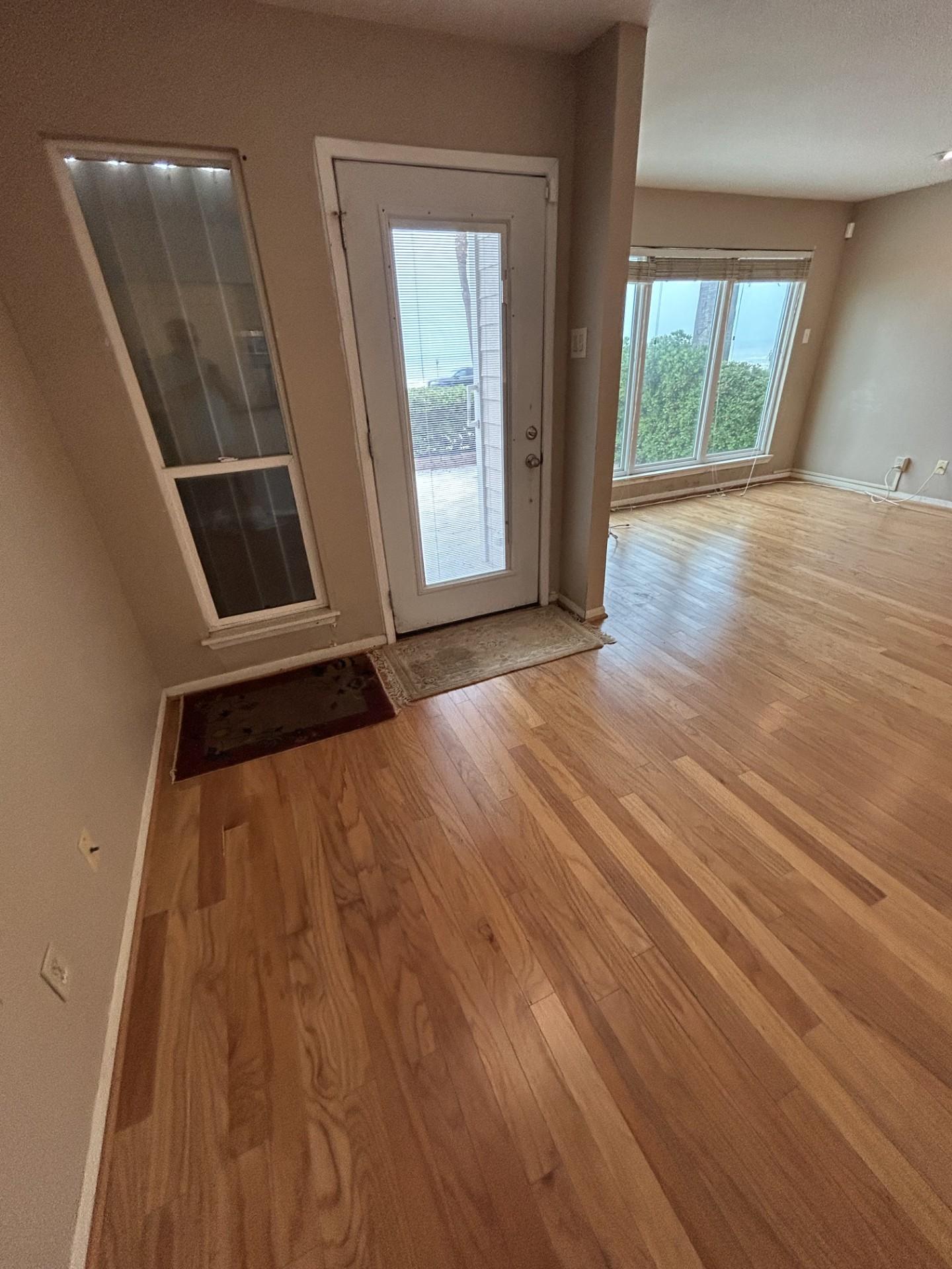 Image 3: Front door and living room to the side. There are