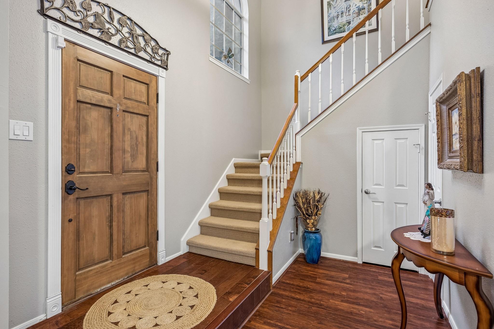 Image 2: This inviting entryway features a warm wooden door