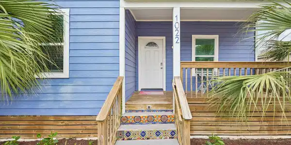 Image 3: Welcoming front entry with a covered porch and woo