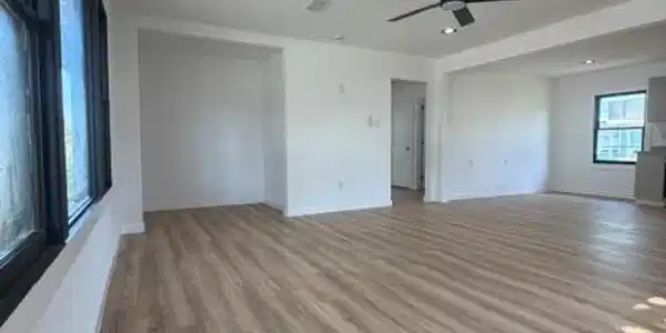 Image 3: This bright, spacious room features sleek wood flo